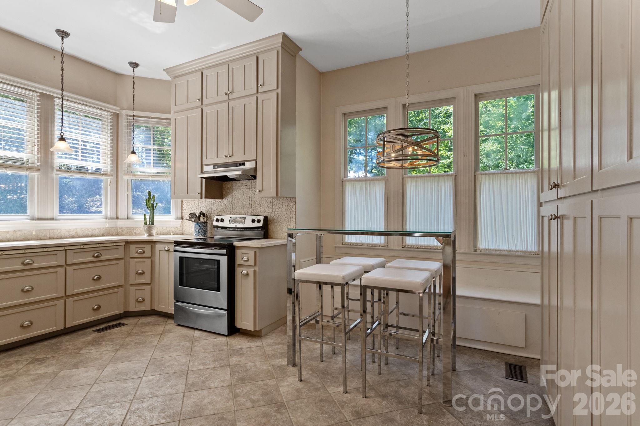 2825 Hunting Country Road Tryon, NC 28782 - Photo 11 of 41 a kitchen with a stove a table and chairs in it