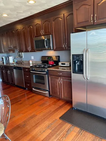 a kitchen with stainless steel appliances granite countertop a stove a sink dishwasher and a refrigerator