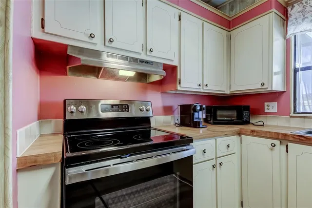a kitchen with stainless steel appliances granite countertop a stove and cabinets