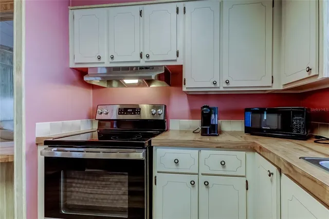 a kitchen with stainless steel appliances granite countertop a stove and cabinets