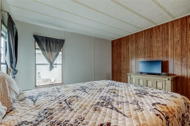 a bedroom with a bed and a flat screen tv in kitchen