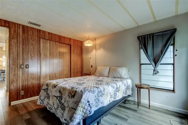 a bedroom with a bed a mirror and a window