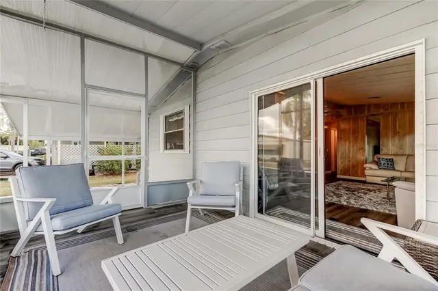 a view of a porch with a table and chairs