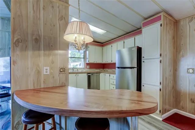 a view of a dining room with furniture a chandelier and wooden floor