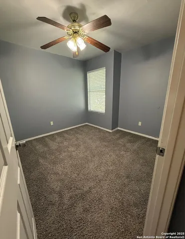 en empty room with windows and fan