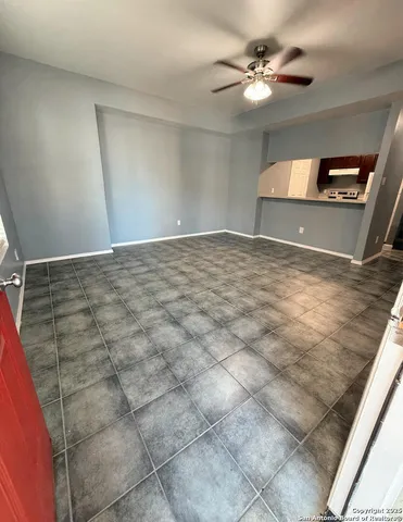 a view of a big room with a ceiling fan and window