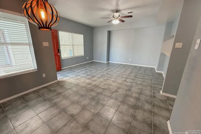 en empty room with windows and fan