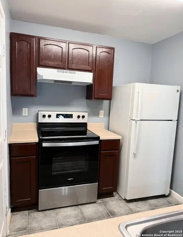 a kitchen with a refrigerator and a stove