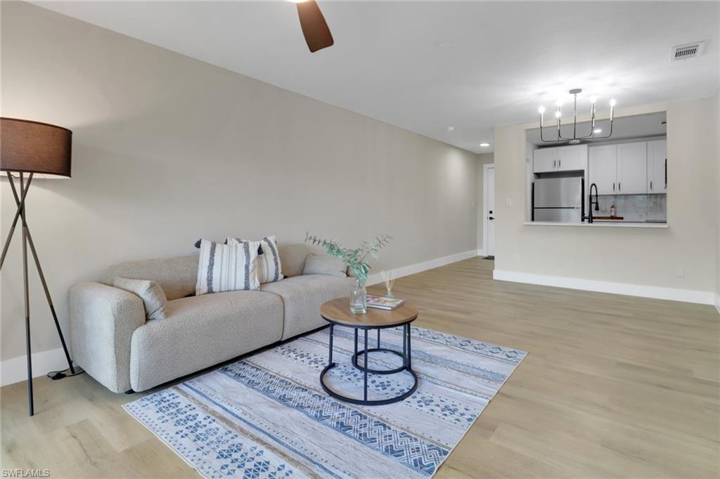 1195 Clam Court, Unit 202 Naples, FL 34102 - Photo 11 of 18 a living room with furniture and a chandelier