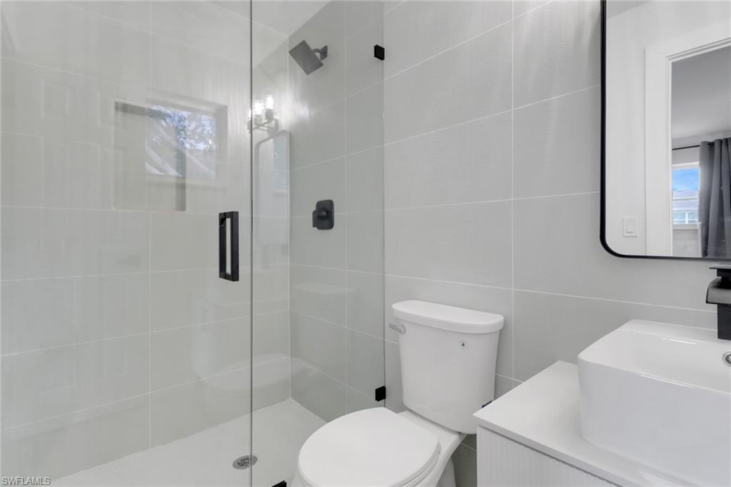 1195 Clam Court, Unit 202 Naples, FL 34102 - Photo 15 of 18 a white toilet sitting next to a bathroom sink
