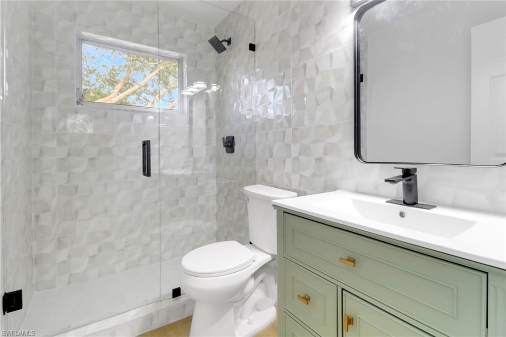 1195 Clam Court, Unit 202 Naples, FL 34102 - Photo 18 of 18 a bathroom with a sink a toilet and shower