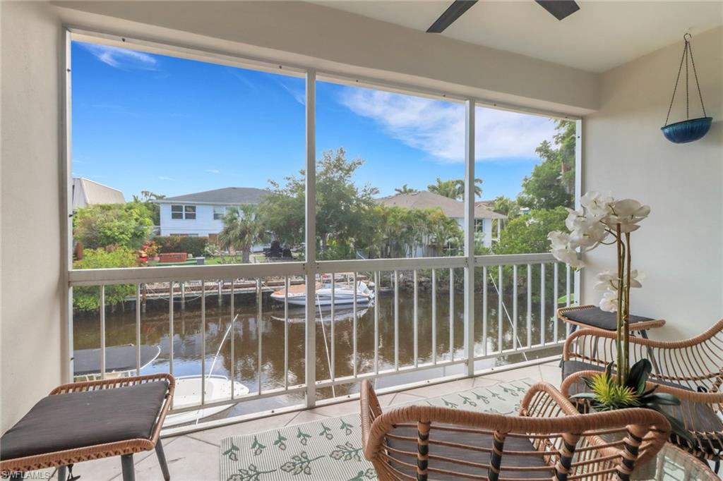 1195 Clam Court, Unit 202 Naples, FL 34102 - Photo 4 of 18 a view of a balcony with wooden floor and outdoor seating