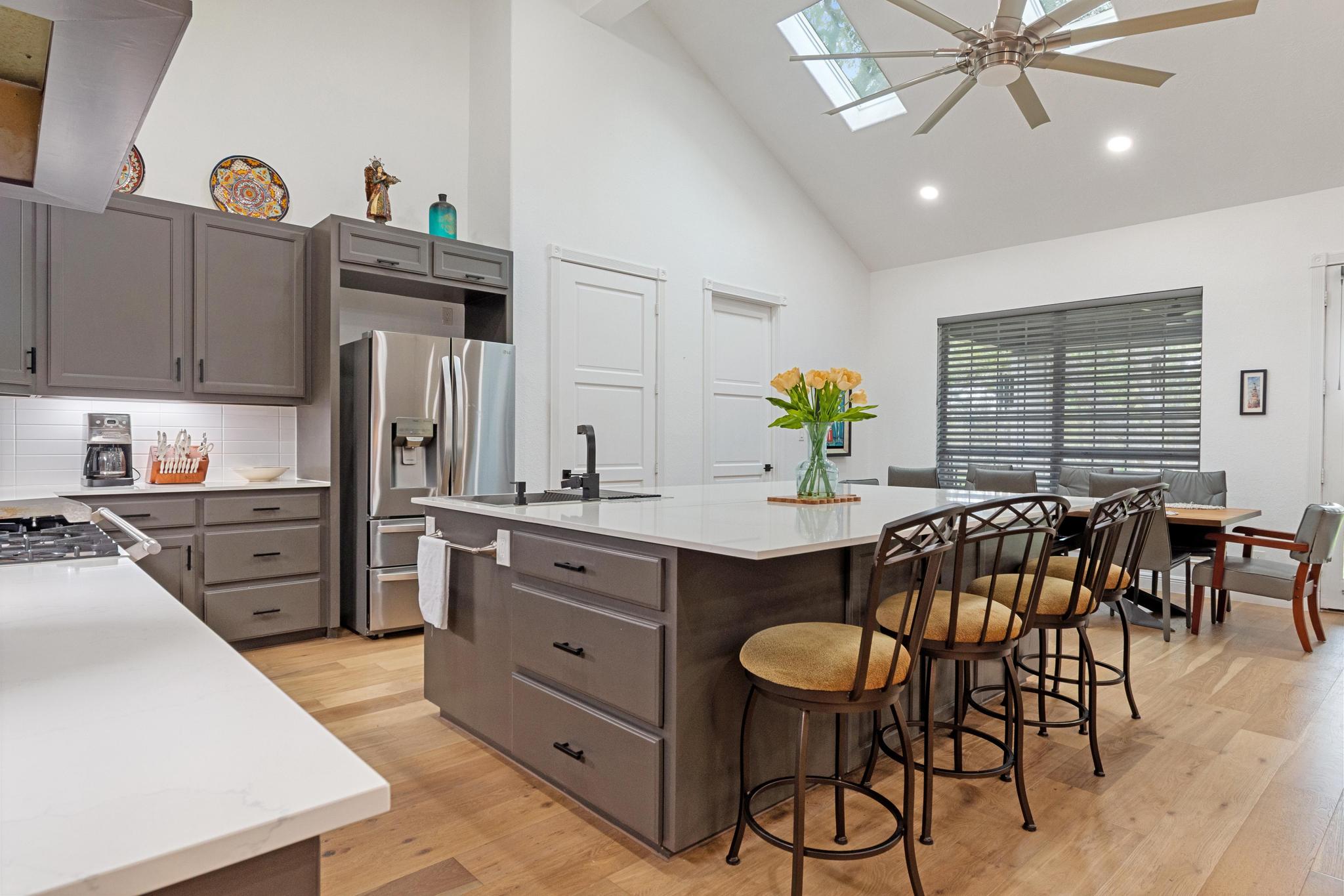 346 The Oaks Boulevard Elgin, TX 78621 - Photo 12 of 39 a kitchen with stainless steel appliances kitchen island granite countertop a table chairs and a refrigerator