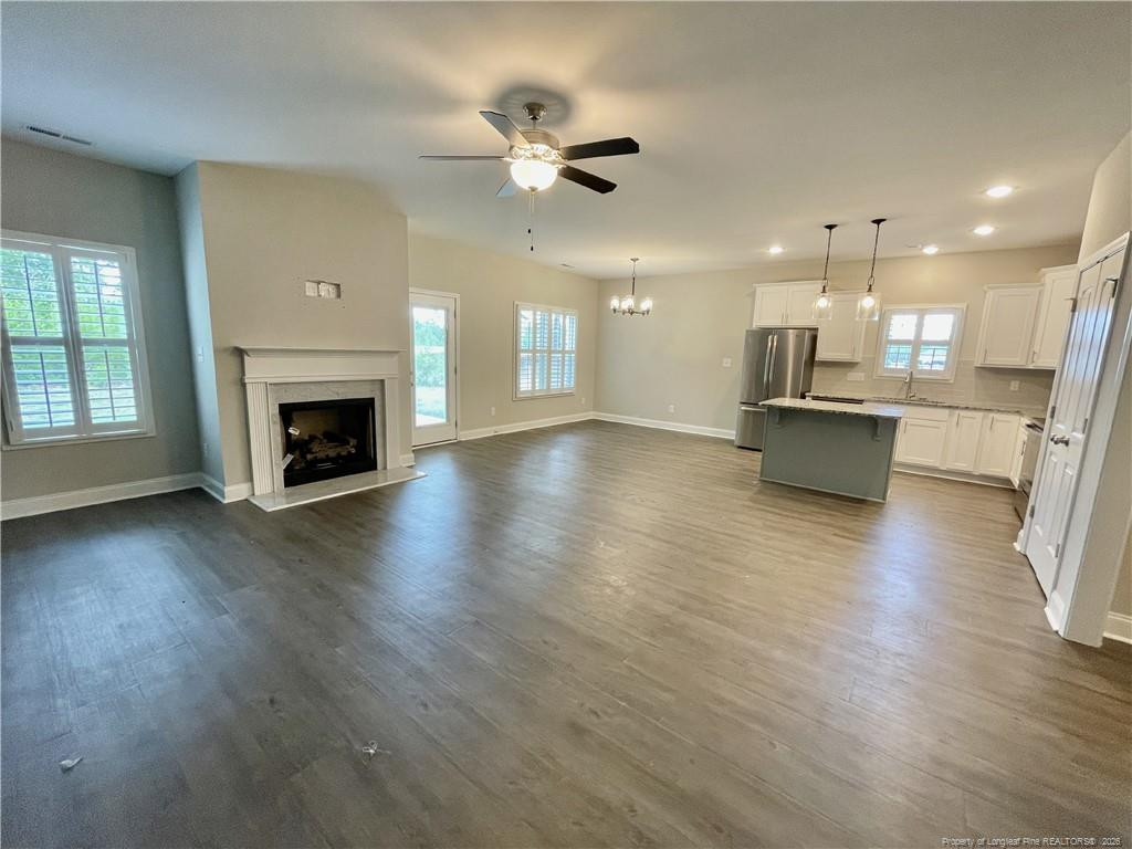 5177 Maxwell Road Stedman, NC 28391 - Photo 4 of 24 an open kitchen with fireplace and wooden floor