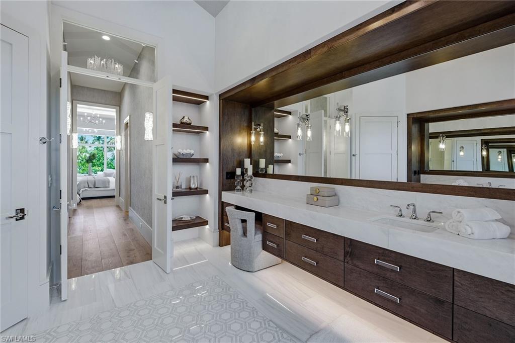 529 Neapolitan Way Naples, FL 34103 - Photo 15 of 26 a spacious bathroom with a granite countertop sink a mirror and shower
