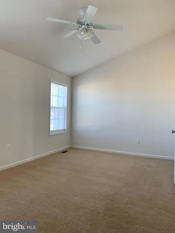an empty room with windows and ceiling fan view