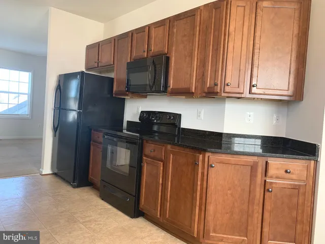 a kitchen with stainless steel appliances granite countertop a refrigerator stove and microwave