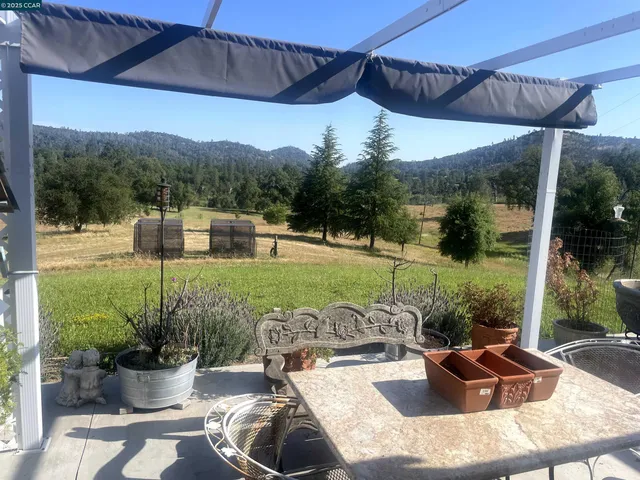 a view of a backyard with lawn chairs and a fire pit