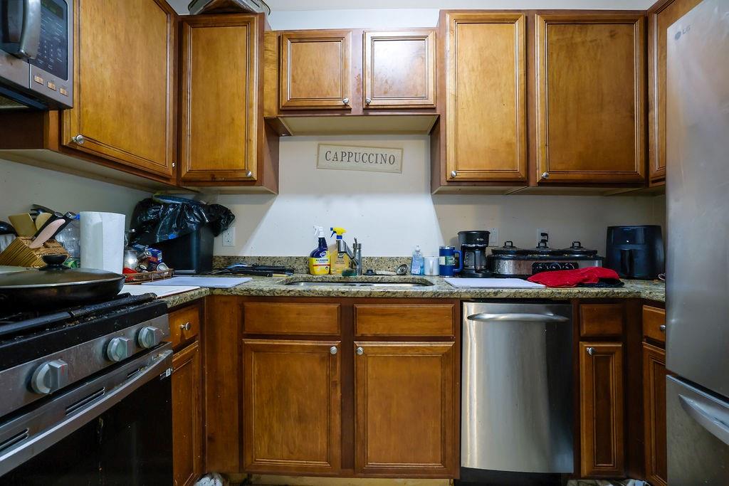 6980 Roswell Road, Unit B11 Atlanta, GA 30328 - Photo 9 of 14 a kitchen with stainless steel appliances granite countertop a sink stove and cabinets