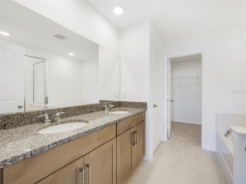 671 Clark Street Oviedo, FL 32765 - Photo 18 of 24 a bathroom with a granite countertop sink and a mirror