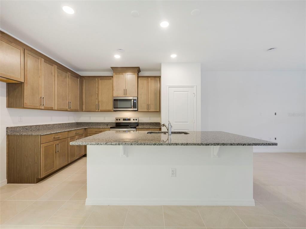 671 Clark Street Oviedo, FL 32765 - Photo 9 of 24 a kitchen with stainless steel appliances granite countertop a sink a stove and a refrigerator
