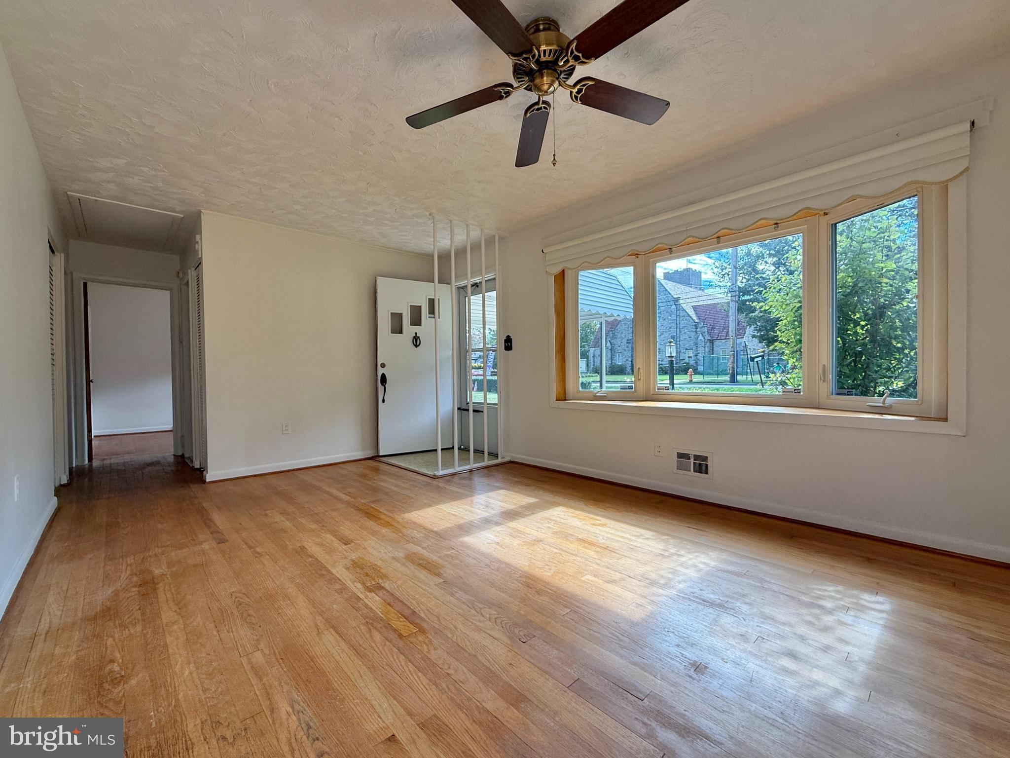 2002 Old Frederick Road Baltimore, MD 21228 - Photo 4 of 36 a view of an empty room with a window and wooden floor