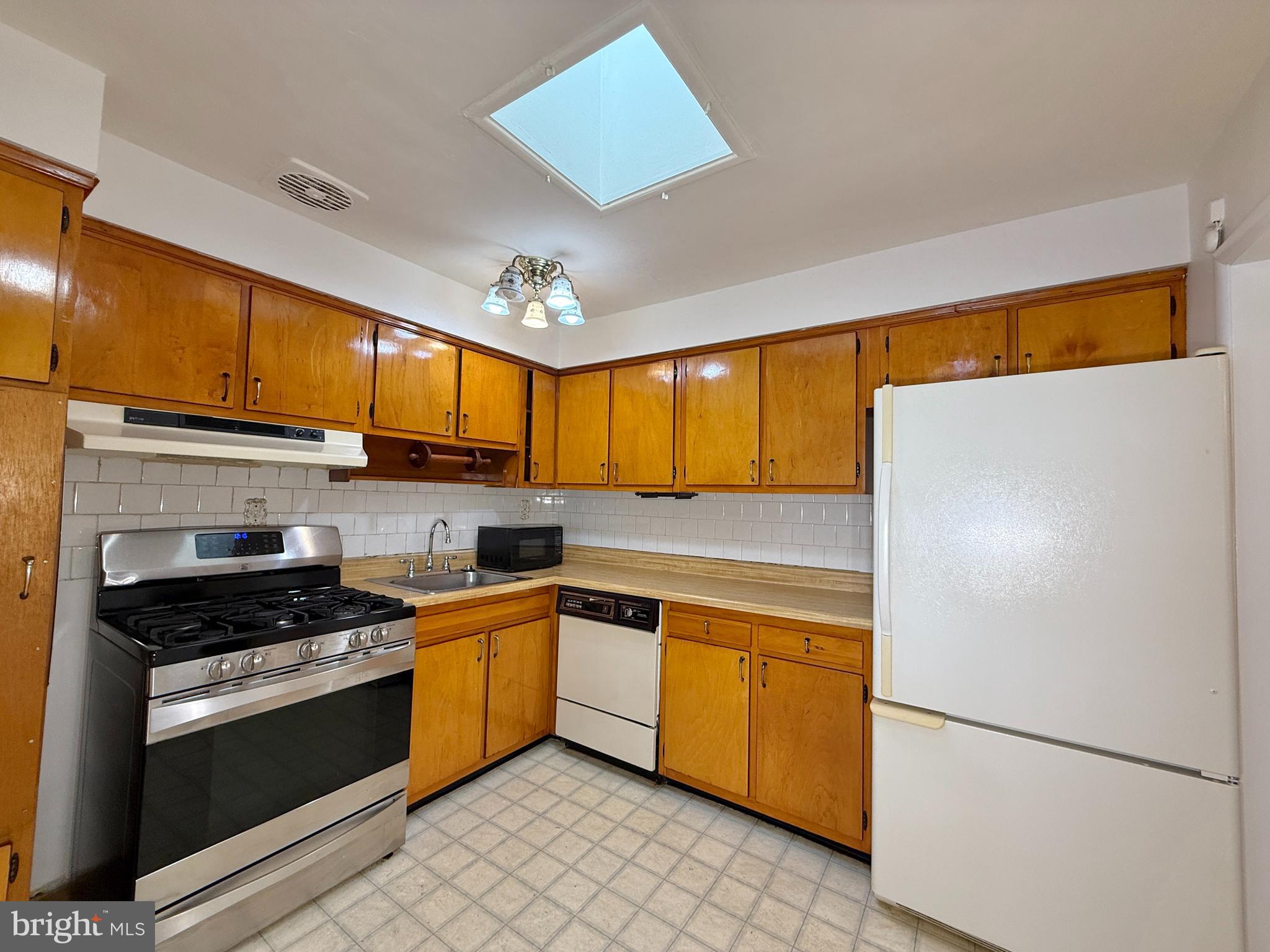 2002 Old Frederick Road Baltimore, MD 21228 - Photo 9 of 36 a kitchen with stainless steel appliances granite countertop a refrigerator a sink dishwasher a stove with white cabinets and wooden floor