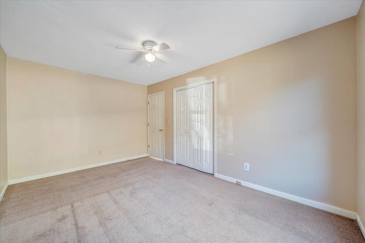4902 Old Mountain Road Northeast Roanoke, VA 24019 - Photo 18 of 42 an empty room with a chandelier fan and windows