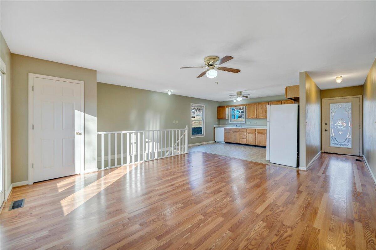 4902 Old Mountain Road Northeast Roanoke, VA 24019 - Photo 5 of 42 a view of a livingroom with wooden floor and a ceiling fan