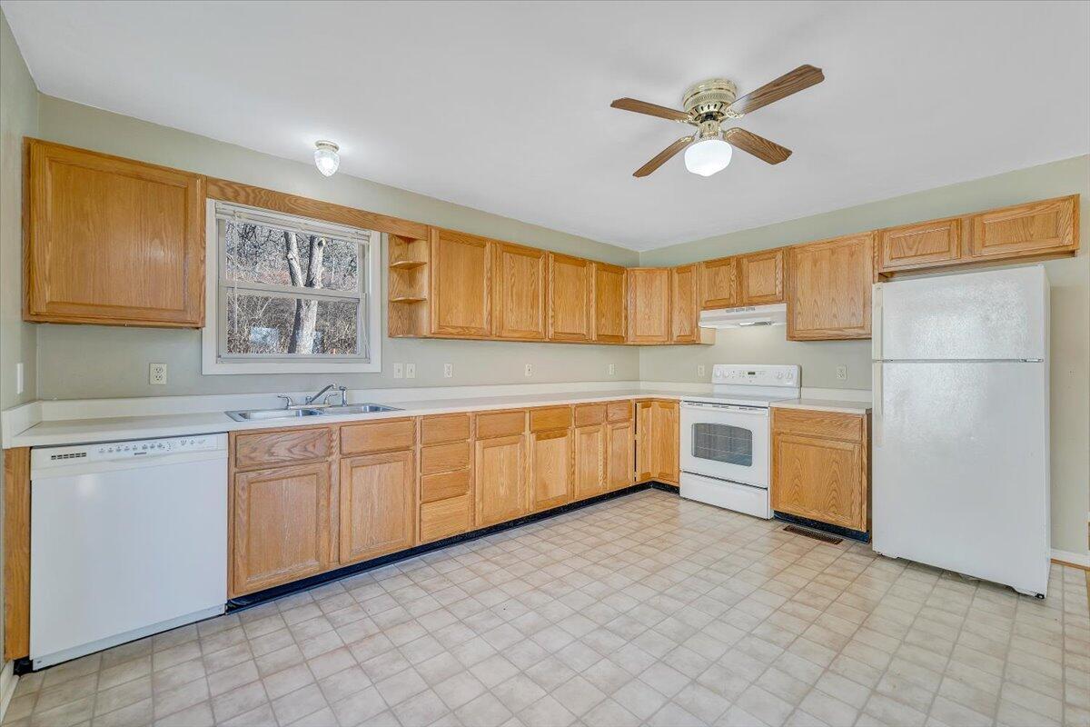 4902 Old Mountain Road Northeast Roanoke, VA 24019 - Photo 8 of 42 a kitchen with a refrigerator a sink and dishwasher with a large window