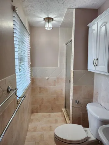 a bathroom with a toilet a sink and shower