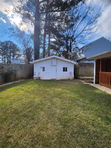 a view of a house with a yard and a large tree