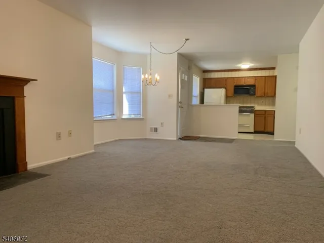 a view of empty room with a kitchen