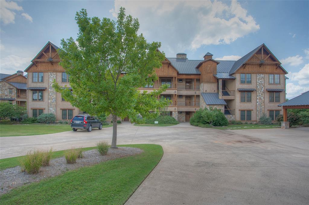 a view of a big house with a big yard and large trees
