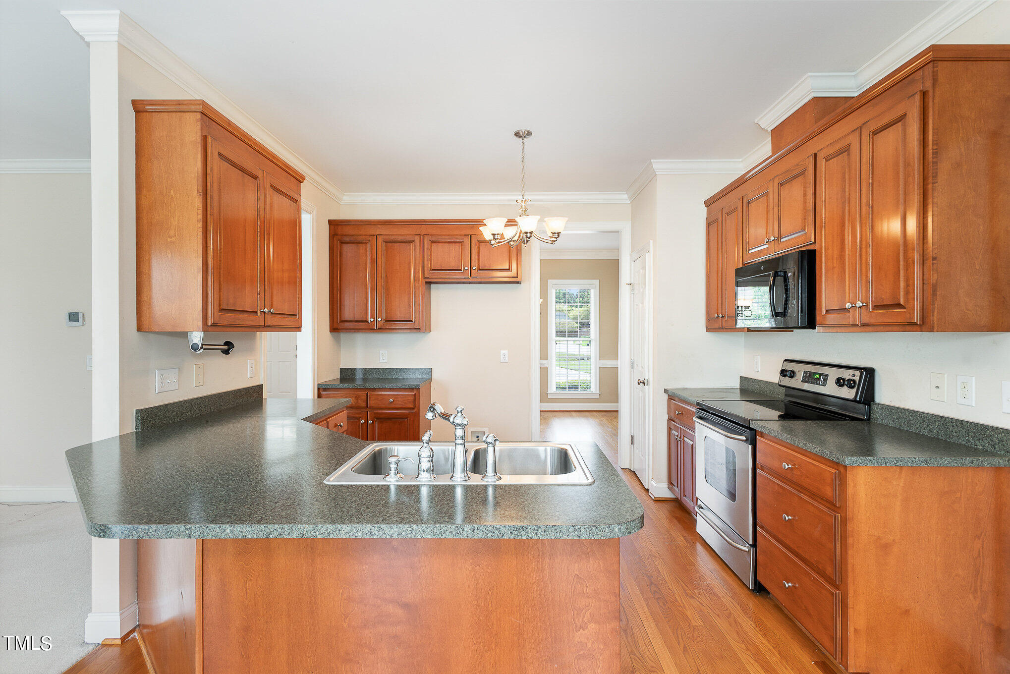 2809 Oak Bridge Drive Raleigh, NC 27610 - Photo 12 of 37 a kitchen with stainless steel appliances granite countertop a sink dishwasher stove and microwave with wooden floor