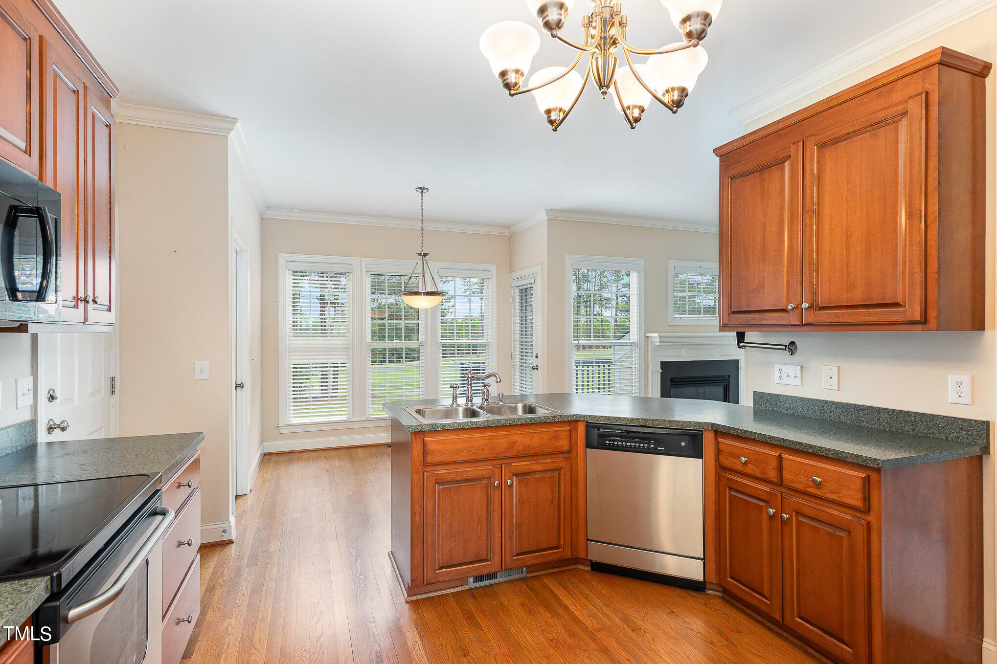 2809 Oak Bridge Drive Raleigh, NC 27610 - Photo 13 of 37 a kitchen with stainless steel appliances wooden floors and white cabinets