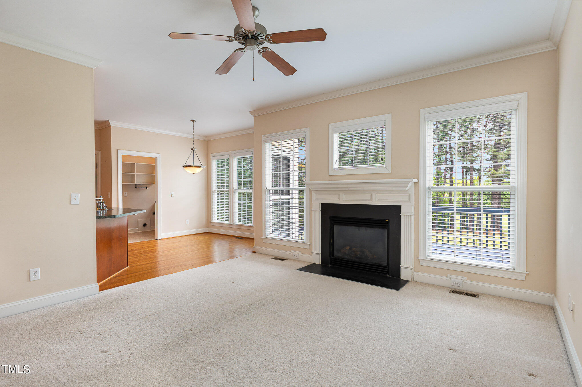 2809 Oak Bridge Drive Raleigh, NC 27610 - Photo 10 of 37 a view of a livingroom with a fireplace a ceiling fan windows and a ceiling fan