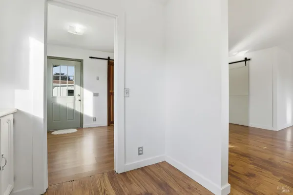 a view of an empty room with wooden floor