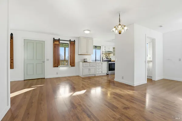 a view of an empty room with wooden floor