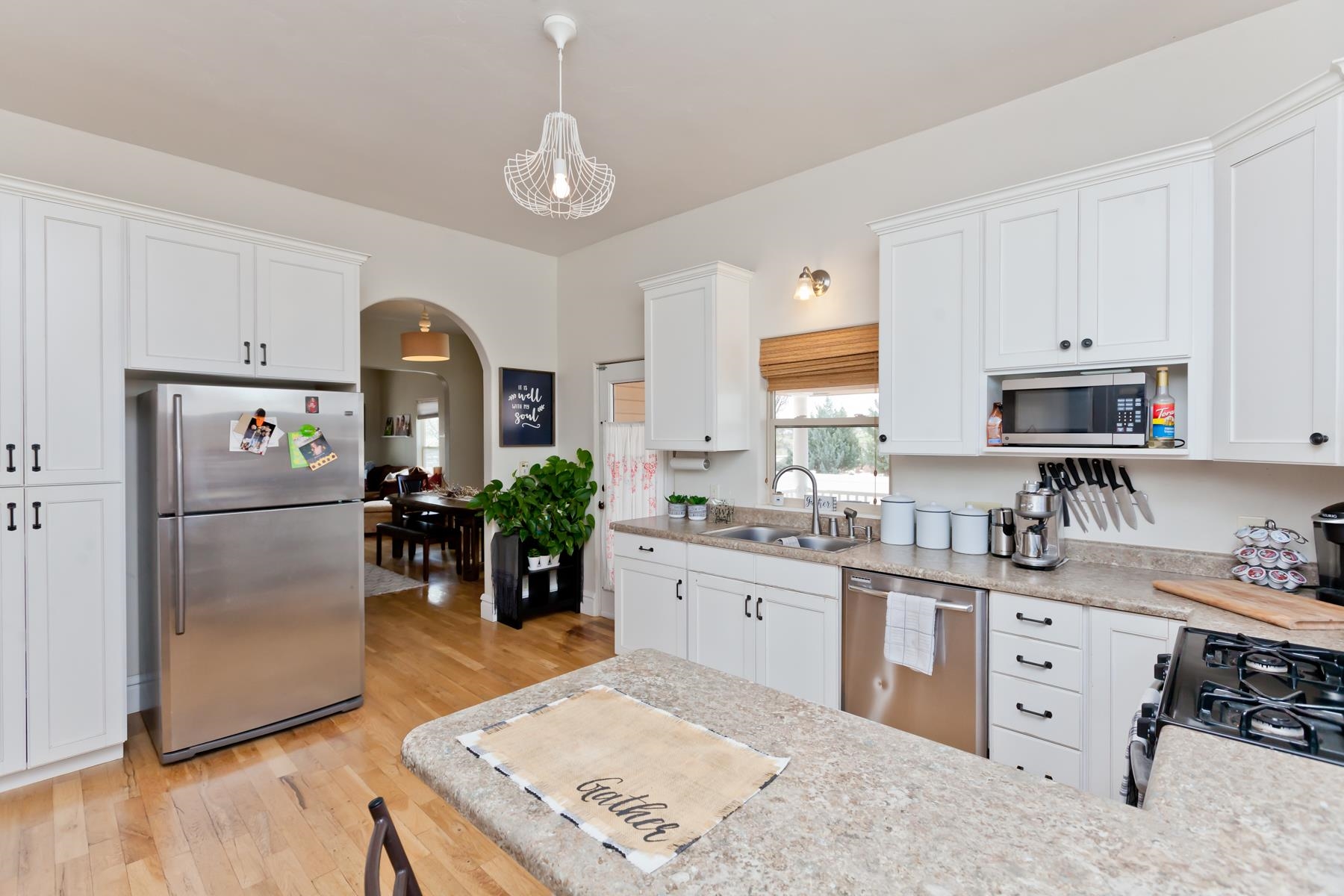 225 29 Road Grand Junction, CO 81503 - Photo 21 of 41 a kitchen with stainless steel appliances granite countertop a refrigerator a sink a stove a dining table and chairs with wooden floor