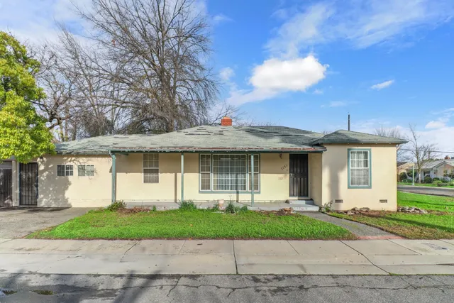 a front view of a house with a yard and potted plants