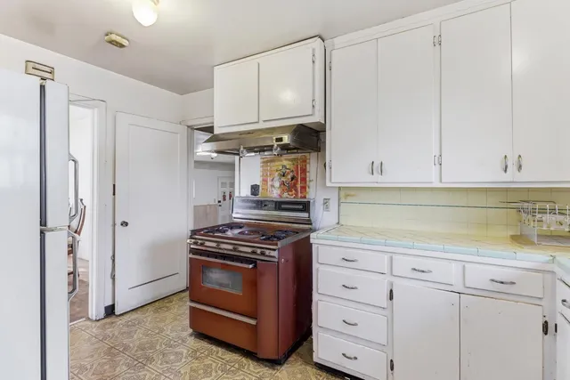 a kitchen with white cabinets and white appliances