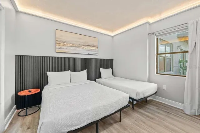 a bedroom with a bed and wooden floor