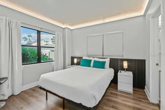 a large bedroom with a bed and wooden floor