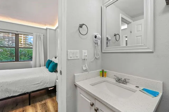 a bathroom with a granite countertop sink mirror vanity and toilet