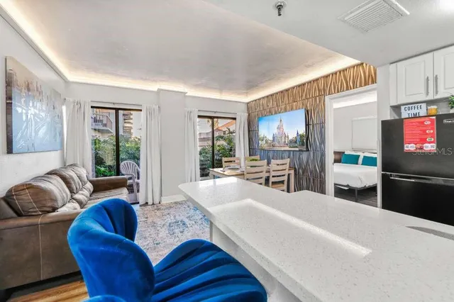 a kitchen with stainless steel appliances granite countertop a refrigerator a stove a sink and a dining table with wooden floor