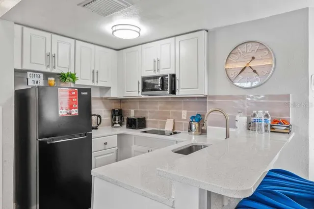 a kitchen with a refrigerator a stove cabinets and wooden floor