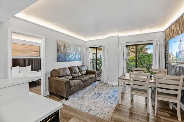 a living room with furniture a flat screen tv and a floor to ceiling window