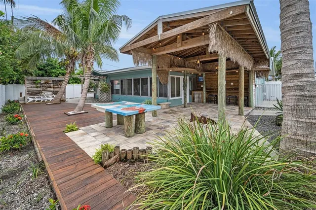 a view of a house with a yard and palm trees