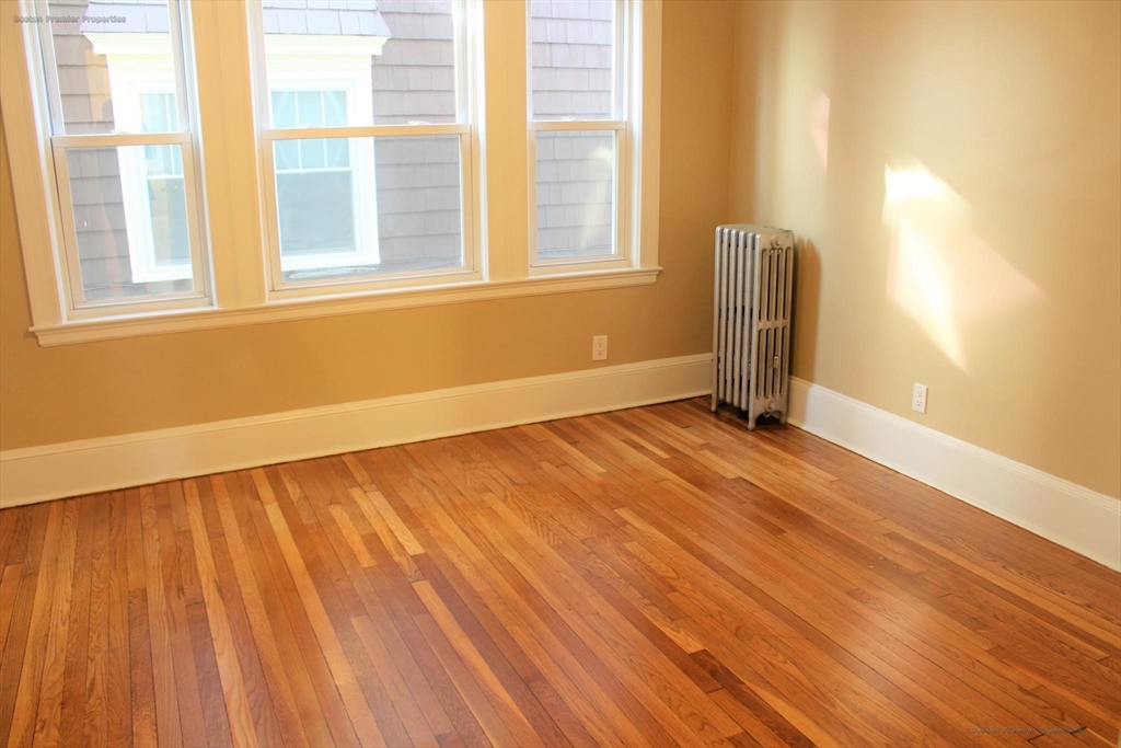 14 Ginita Street, Unit 1 Boston, MA 02122 - Photo 3 of 12 a view of an empty room with wooden floor and a window